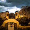 Santuario De Chimayo Clouds by Rick Casados